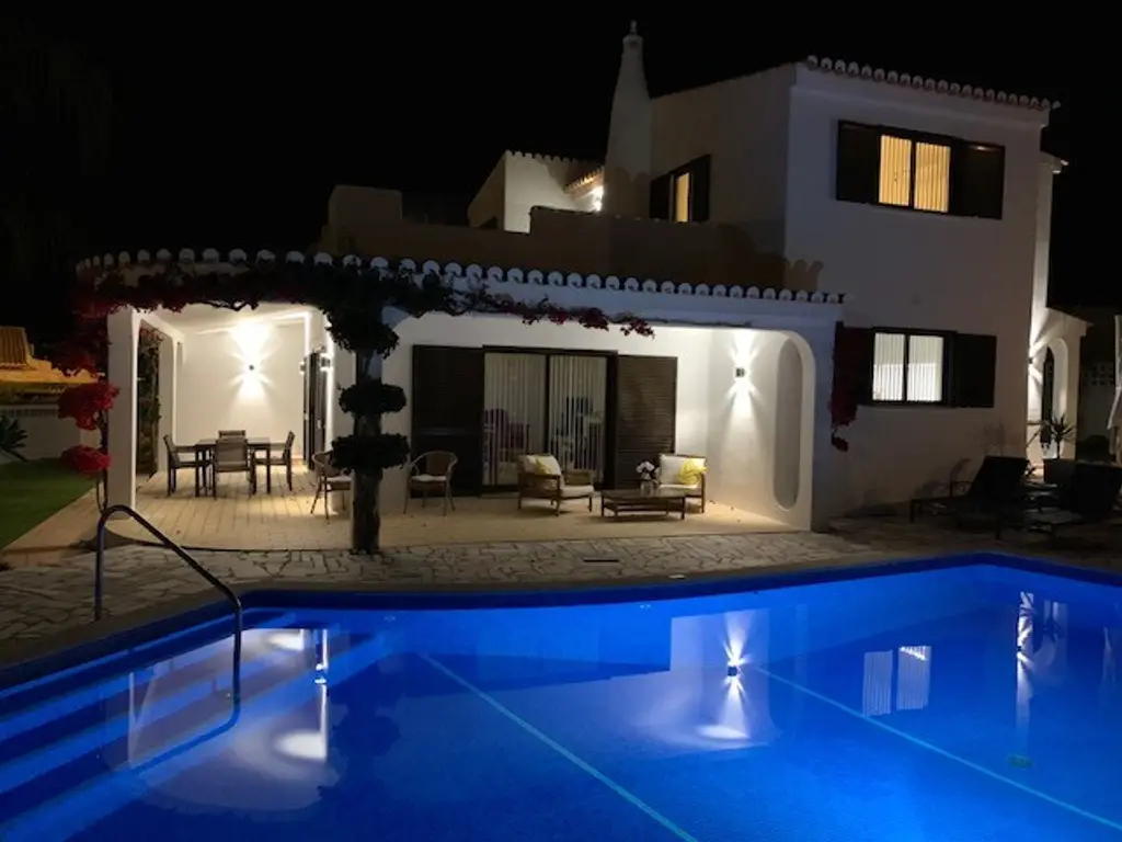The villa swimming pool illuminated at night